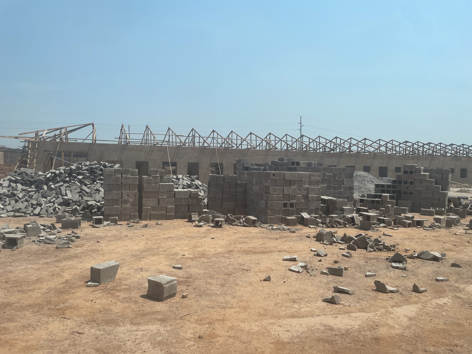 Industrial warehouse structural construction by Ubuntu Groupe SARL — masonry and roof trusses